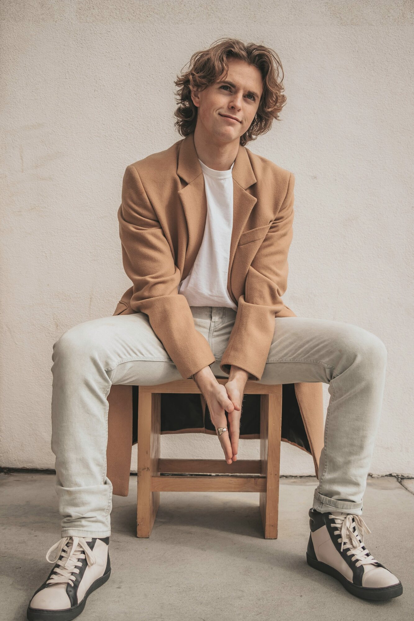 Homme assis portant une veste camel